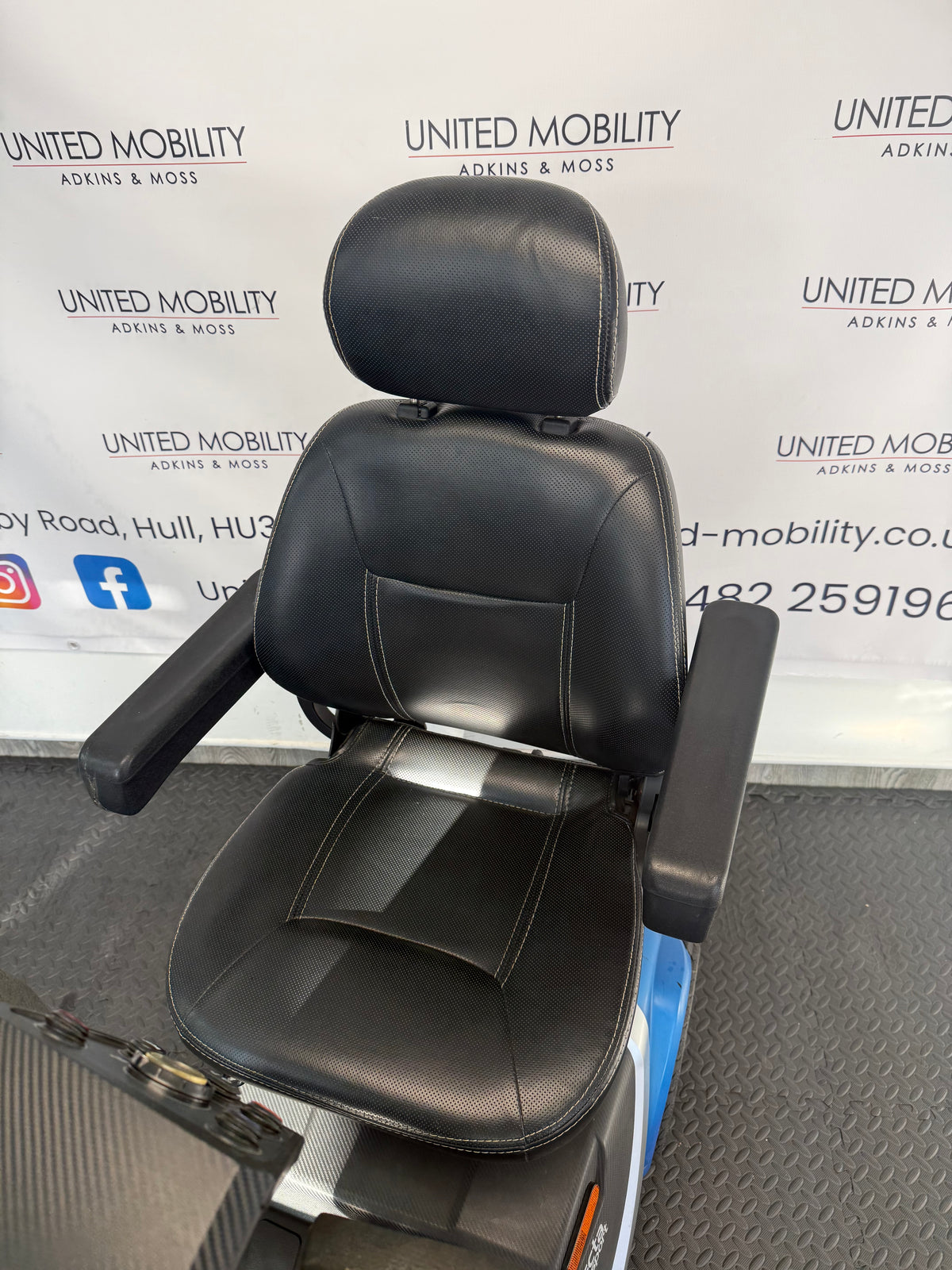 Black mobility scooter seat and headrest with blue scooter body behind