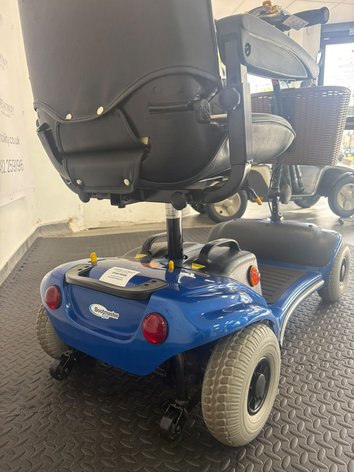 Blue Eden Bootmaster mobility scooter rear three-quarter view with black seat