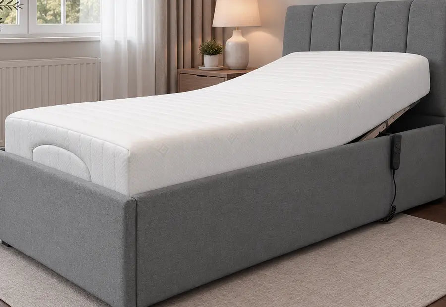 Upholstered adjustable bed with grey fabric frame and white mattress, paneled headboard
