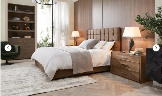 Modern bedroom with a wooden bed, nightstand, and plants, featuring warm lighting.