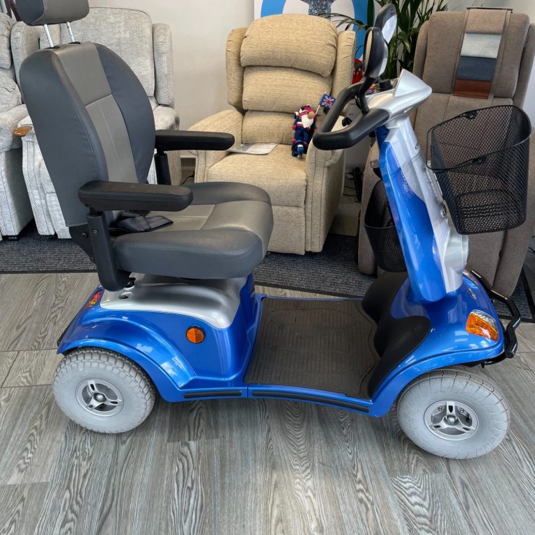 A blue and black mobility scooter parked indoors, with a comfortable seat and armrests.