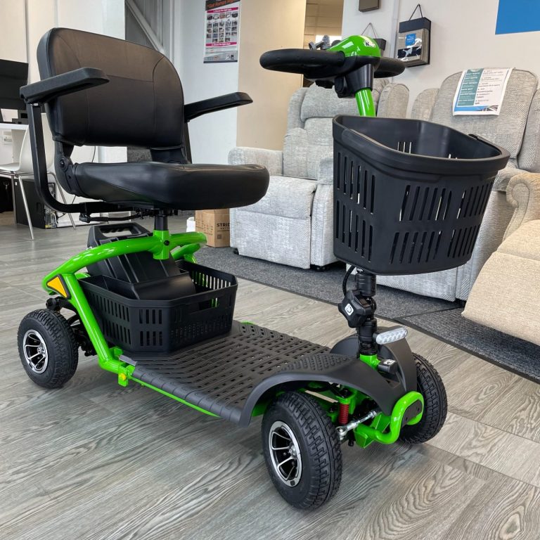 A compact green mobility scooter with a black seat and storage basket.