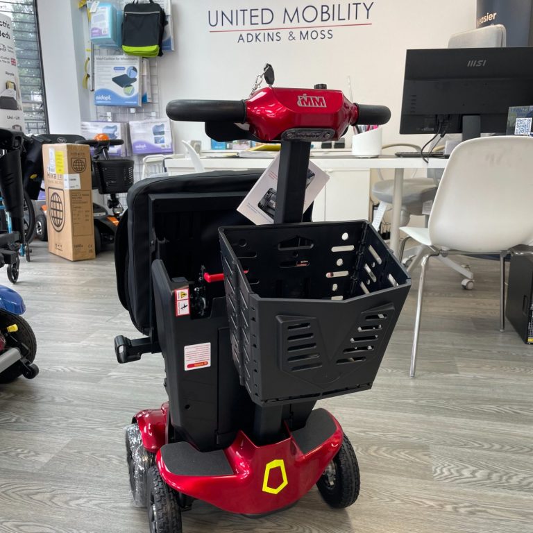 Red mobility scooter with a black basket, set in a store environment.